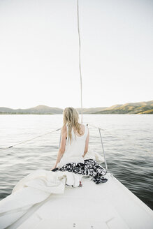Blondes Teenager-Mädchen sitzt auf einem Segelboot. - MINF07448