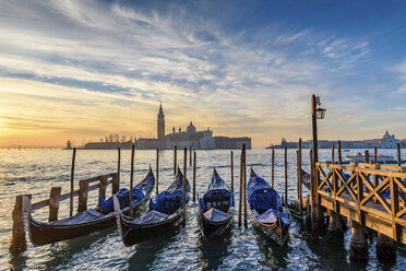 Gondolas moored on a canal in Venice, Italy, at sunrise. - MINF07489