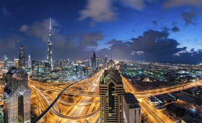 Stadtbild von Dubai, Vereinigte Arabische Emirate, in der Abenddämmerung, mit dem Burj Khalifa und anderen Wolkenkratzern und der beleuchteten Autobahn in der Mitte. - MINF07506