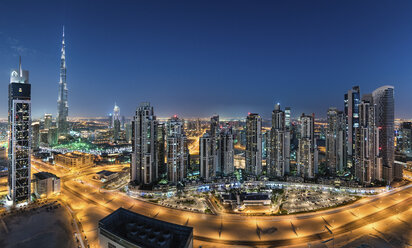 Stadtbild von Dubai, Vereinigte Arabische Emirate, in der Abenddämmerung, mit beleuchteten Wolkenkratzern im Vordergrund. - MINF07508