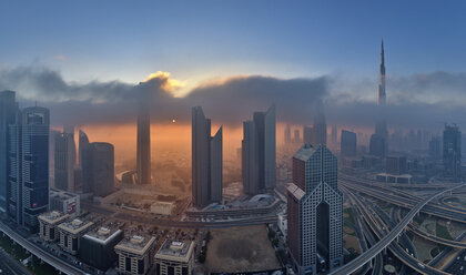 Stadtbild mit beleuchteten Wolkenkratzern in Dubai, Vereinigte Arabische Emirate, in der Abenddämmerung. - MINF07512