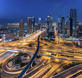 Cityscape of Dubai, United Arab Emirates at dusk, with skyscrapers and illuminated highways in the foreground. - MINF07515