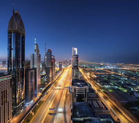 Stadtbild von Dubai, Vereinigte Arabische Emirate, in der Abenddämmerung, mit Wolkenkratzern entlang beleuchteter Straßen., lizenzfreies Stockfoto