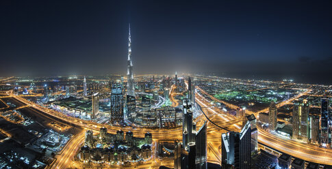 Stadtbild von Dubai, Vereinigte Arabische Emirate, bei Nacht, mit dem Burj Khalifa-Wolkenkratzer in der Ferne. - MINF07532