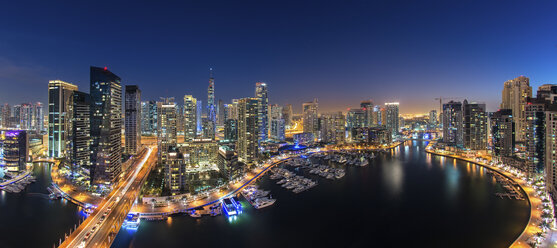 Stadtbild von Dubai, Vereinigte Arabische Emirate, in der Abenddämmerung, mit beleuchteten Wolkenkratzern und dem Yachthafen im Vordergrund. - MINF07538