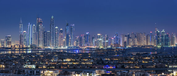 Stadtbild von Dubai, Vereinigte Arabische Emirate, in der Abenddämmerung, mit beleuchteten Wolkenkratzern in der Ferne. - MINF07542