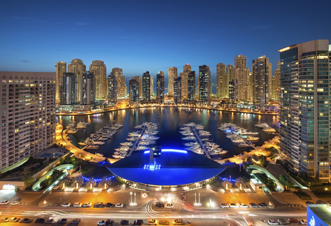 Stadtbild von Dubai, Vereinigte Arabische Emirate, in der Abenddämmerung, mit beleuchteten Wolkenkratzern und dem Yachthafen im Vordergrund., lizenzfreies Stockfoto