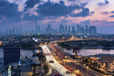 Stadtbild von Dubai, Vereinigte Arabische Emirate, in der Abenddämmerung, mit Autobahn über den Yachthafen und Wolkenkratzern in der Ferne. - MINF07554