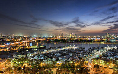 Stadtbild mit beleuchteten Wolkenkratzern und Yachthafen in Dubai, Vereinigte Arabische Emirate, in der Abenddämmerung. - MINF07576