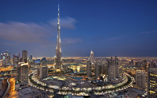 Stadtbild von Dubai, Vereinigte Arabische Emirate, in der Abenddämmerung, mit dem Burj Khalifa-Wolkenkratzer und beleuchteten Gebäuden im Vordergrund. - MINF07579