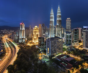 Stadtbild von Kuala Lumpur, Malaysia, in der Abenddämmerung, mit beleuchteten Petronas Towers. - MINF07592