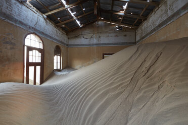 Ein Blick in einen Raum in einem verlassenen Gebäude voller Sand. - MINF07603