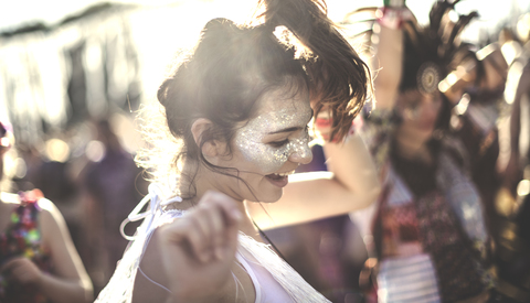 Junge Frau auf einem Sommermusikfestival, die in der Menge tanzt., lizenzfreies Stockfoto