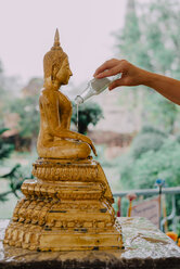 Thailand, Bangkok, Gläubige Menschen baden eine Buddha-Statue mit einer heiligen Kräuterflüssigkeit - GEMF02290