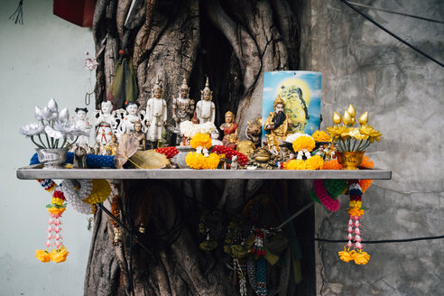 Thailand, Bangkok, Altar mit buddhistischen religiösen Figuren in einem Baum - GEMF02292