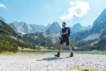 Austria, Tyrol, Man hiking at Seebensee Lake - DIGF04736