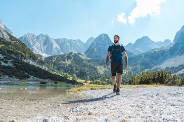 Austria, Tyrol, Man hiking at Seebensee Lake - DIGF04737