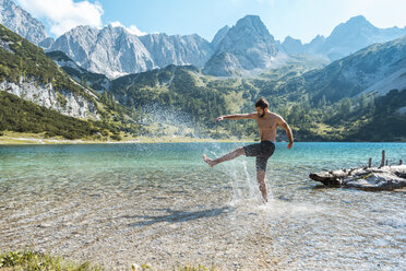 Österreich, Tirol, Junger Mann am Seebensee beim Wassertreten, Spaß haben - DIGF04750