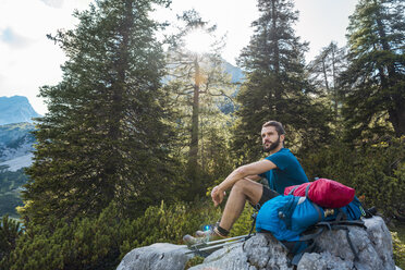 Austria, Tyrol, Hiker taking a break, sitting on a rock - DIGF04753