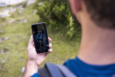 Österreich, Tirol, Wanderer mit Kompass-App am Seebensee - DIGF04756