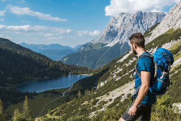 Austria, Tyrol, Young man hiking in the maountains at Lake Seebensee - DIGF04759