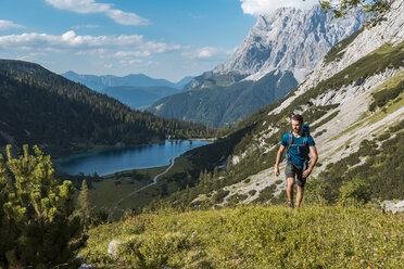 Austria, Tyrol, Young man hiking in the maountains at Lake Seebensee - DIGF04761