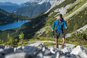 Österreich, Tirol, Junger Mann beim Wandern in den Bergen am Seebensee - DIGF04769