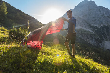 Österreich, Tirol, Wanderer schlägt sein Zelt in den Bergen auf - DIGF04777