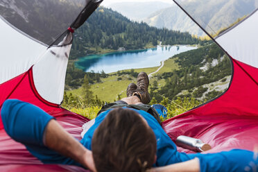 Österreich, Tirol, Wanderer entspannt sich in seinem Zelt in den Bergen am Seebensee - DIGF04785