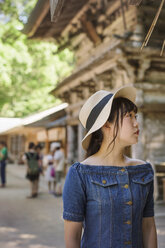 Junge Frau in blauem Kleid und Hut am Shinto Sakurai-Schrein, Fukuoka, Japan. - MINF07738