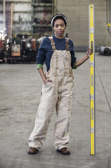 Schwarze Fabrikarbeiterin auf dem Boden einer Blechfabrik. - MINF07849