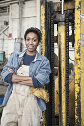 Black woman factory worker and a fork lift in a sheet metal factory. - MINF07858