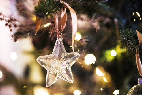 Nahaufnahme eines sternförmigen Glasornaments am Weihnachtsbaum. - MINF07889