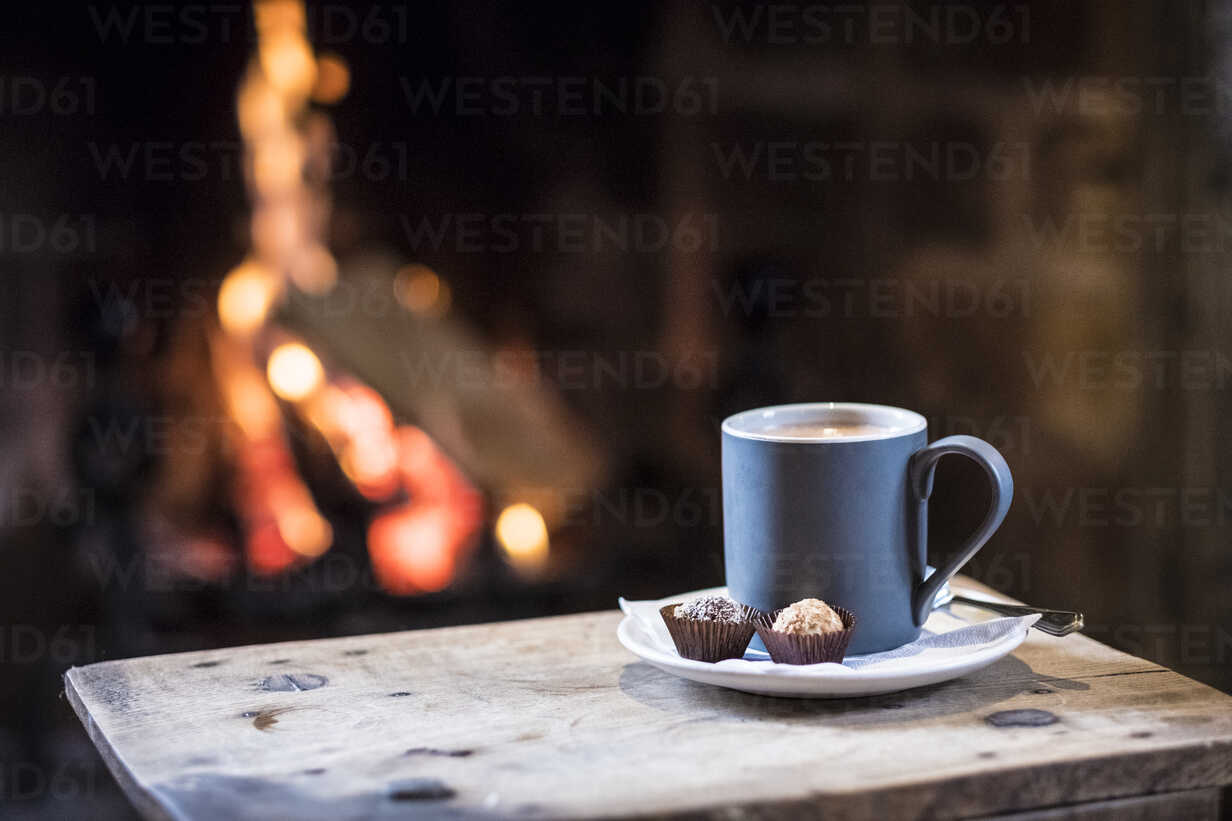 Thermos and Mug with Hot Drink Standing on Wet Wooden Table after