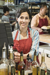 Hispanische Frau an der Kasse einer Bäckerei/eines Coffeeshops. - MINF07928