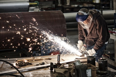Fabrikarbeiter beim Schleifen einer Stahlkante in einer Blechfabrik. - MINF07939