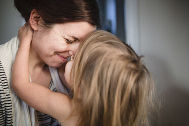 Close up of woman and young girl with blond hair touching noses, smiling and hugging. - MINF07990