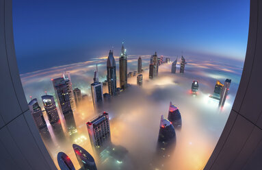 Luftaufnahme einer Stadtlandschaft mit beleuchteten Wolkenkratzern über den Wolken in Dubai, Vereinigte Arabische Emirate, in der Abenddämmerung. - MINF08048