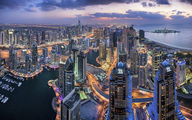 Luftaufnahme des Stadtbilds von Dubai, Vereinigte Arabische Emirate, in der Abenddämmerung, mit beleuchteten Wolkenkratzern und dem Yachthafen im Vordergrund. - MINF08050