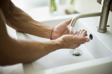 Nahaufnahme einer Person, die sich die Hände an einem Waschbecken wäscht. - MINF08115