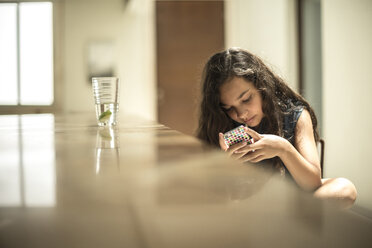 Ein Mädchen sitzt und schaut auf den Bildschirm eines Mobiltelefons. - MINF08123