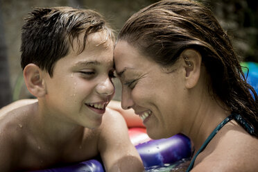 A woman and a boy cuddling in a swimming pool. - MINF08139