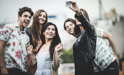 Eine Gruppe von fünf jungen Leuten, die auf einem Dach stehen und für ein Selfie posieren. - MINF08167