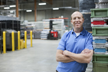 A portrait of a Caucasian male warehouse worker in a large warehouse facility. - MINF08203