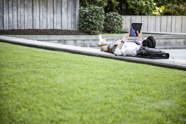 Geschäftsmann in einem Stadtpark in der Innenstadt, der eine Pause macht und sein Notebook überprüft - MINF08225