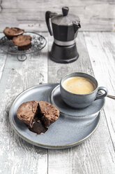 Schokoladenmuffin mit flüssiger Schokolade auf Teller mit Kaffeetasse - SARF03895