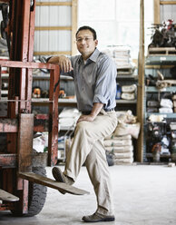 Hispanic man owner of a landscape company standing in the equipment room - MINF08465