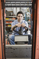 Caucasian man employee driving a forklift for a landscape company. - MINF08466
