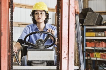 Hispanic woman employee using a forklift in a landscape company. - MINF08469