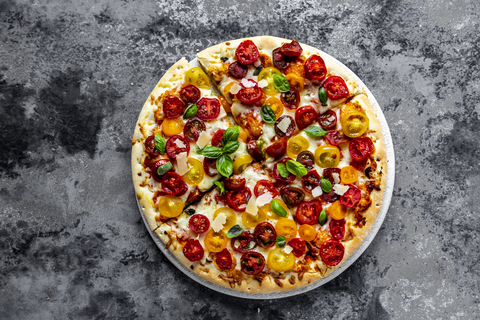 Pizzaschnitten mit Tomaten und Basilikumblättern, lizenzfreies Stockfoto